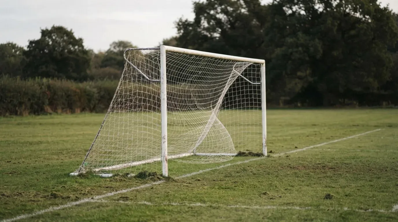 Ein Fussballtor mit locker hängendem Netz auf einem Trainingsplatz, das sich leicht im Wind bewegt.